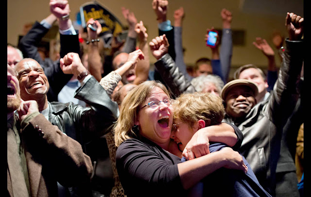 St. Louis — Michelle Zielinski, center, hugs Jared Goudsmit after President Barack Obama is projected to win during an election watch party at the Chase Park Plaza Hotel.