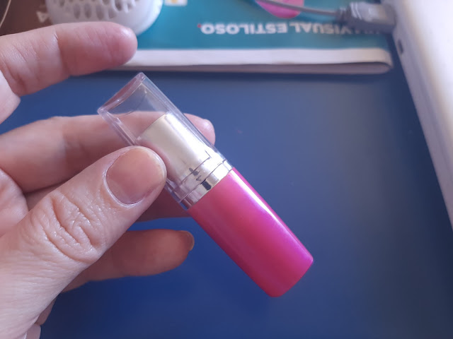 a lipstick with the cap with a hand holding it