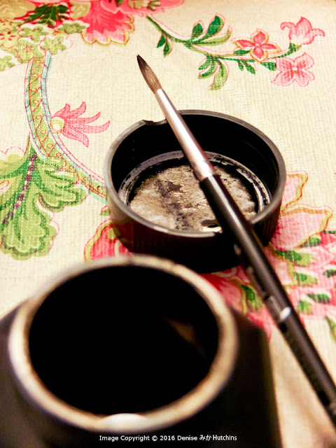 The ink bottle cap is able to hold the brush when not in use.