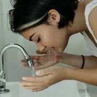 clean your face naturally. A girl washes her face in the sink with water