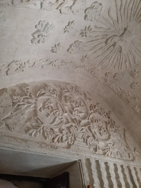 stucco decorations in the form of vines, leaves, stars, flowers, columns and figures