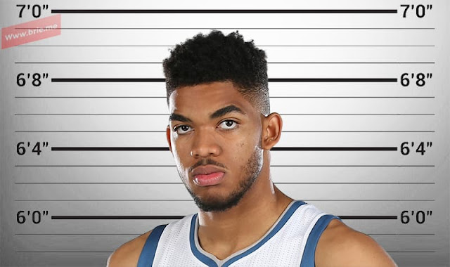 Karl-Anthony Towns posing in front of a height chart background