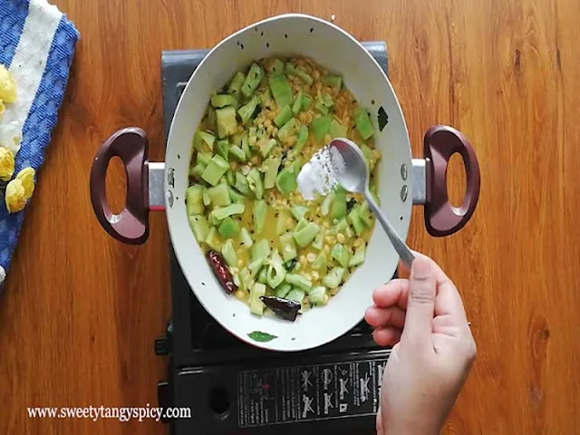 Cooked lentils and seasoning mixed with snake gourd for Pudalangai Kootu