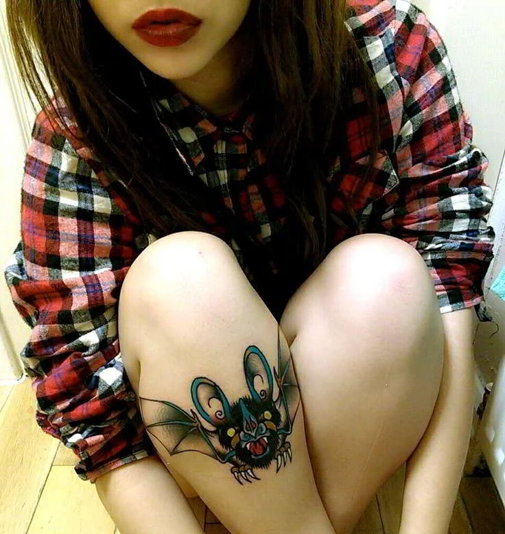 Un tatuaje de murcielago en la perna de una modelo