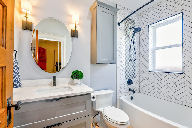 a bathroom with a sink, toilet, mirror and bathtub