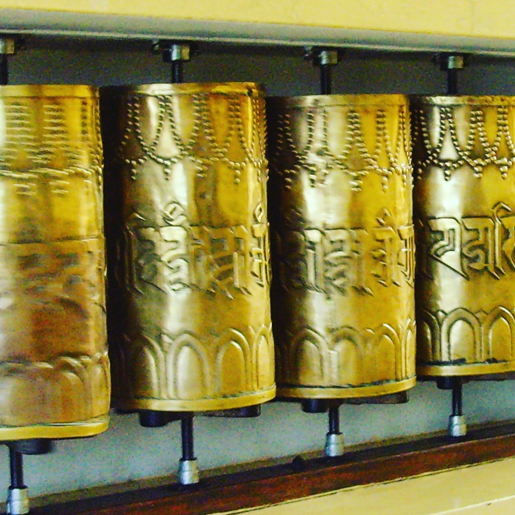 gold prayer wheels in a hall in mcleod ganj, near where the dalai lama gave a four day teaching