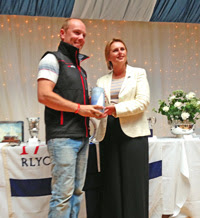 J/70 sailor R. Scott accepting award at Cowes Week Short Series