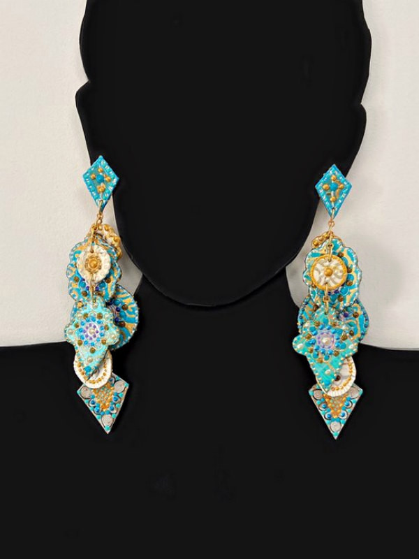 black cardboard bust of woman wearing long dangle earrings composed of decorative paper charms in shades of aqua and gold