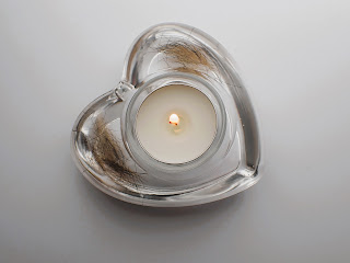 A heart shaped clear tea light holder containing pet hair