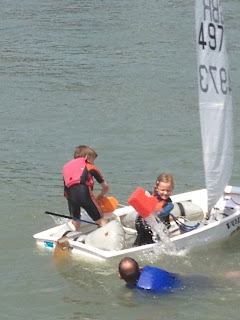 Haydn Sewell teaching Freya Sewell to bail an Optimist