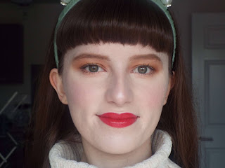 Head shot straight after makeup application. Equal and even base coverage to both sides. Rest of makeup look including warm gold eye look, pink blush and red lip.