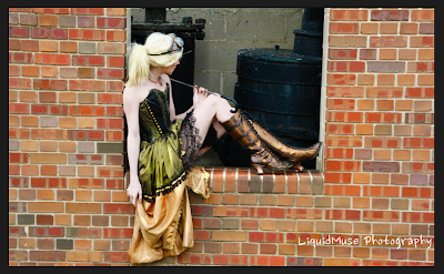 Steampunk costume with green dress, boots, goggles and parasol.