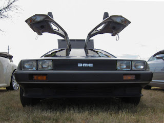 A photo of a DeLorean car with the gullwing doors open