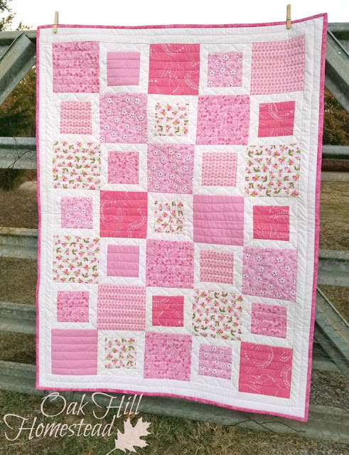 Large and small squares alternate in this girl-y crib quilt. (c) Oak Hill Homestead