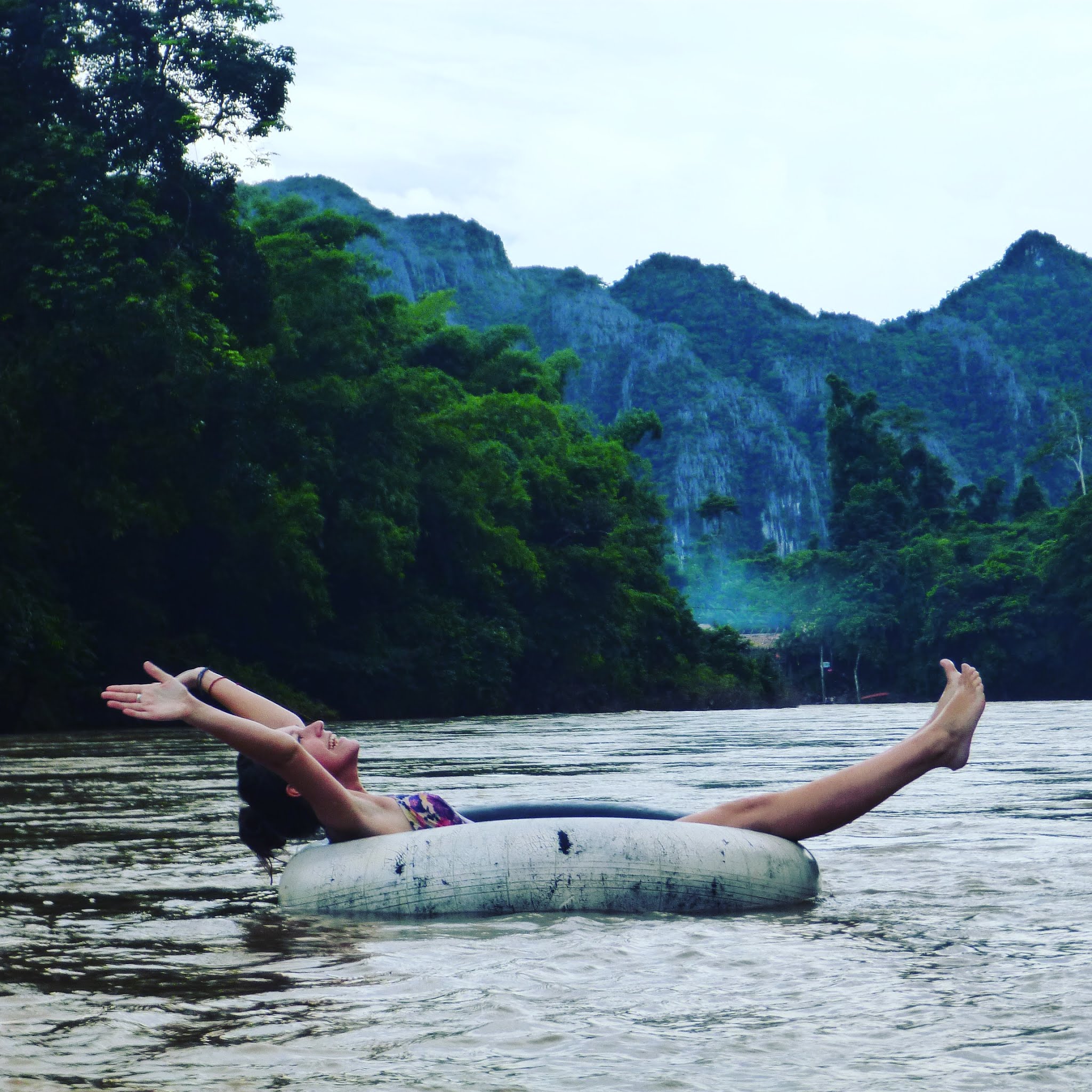 lydia swinscoe floating down mekong river in an inner tube near vang vieng