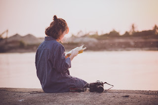 woman reading by water