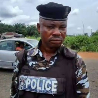 Nigerian police officer stopping vehicle at roadside checkpoint traffic stop