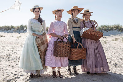 In Greta Gerwig's "Little Women" (2019), the March sisters Meg, Amy, Jo, and Beth (Emma Watson, Florence Pugh, Saoirse Ronan, and Eliza Scanlen) stand on the beach together with baskets for a picnic.