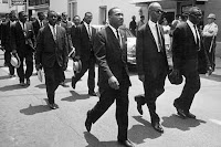 Martin Luther King and others march at the funeral of Medgar Evers