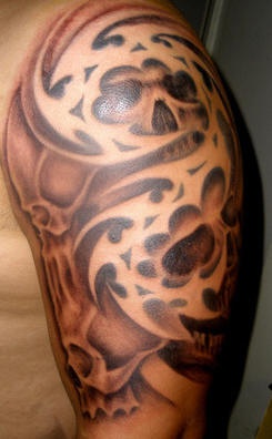 Brown tribal shoulder tattoo with skulls