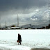A Syrian refugee man carry bread as he walk in the snow