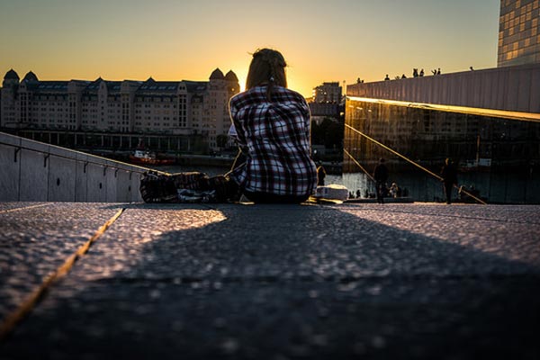 Una mujer sentada observa el atardecer.