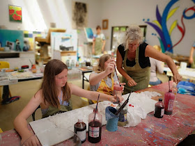 girls learning to tie dye silk