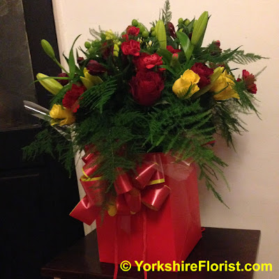  Fresh flowers and berries bouquet in gift bag with gift bow