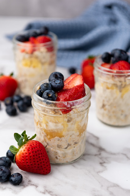 oats in glass jars with berries on top.