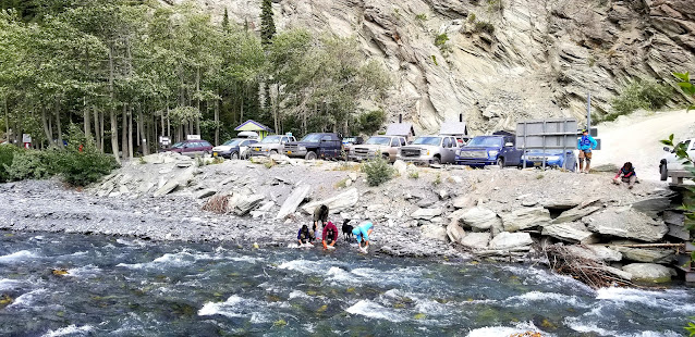 People cleaning their fish at the clear river of O'Brien Creek