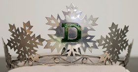 A tiara topped with silver snowflakes and a green "D."