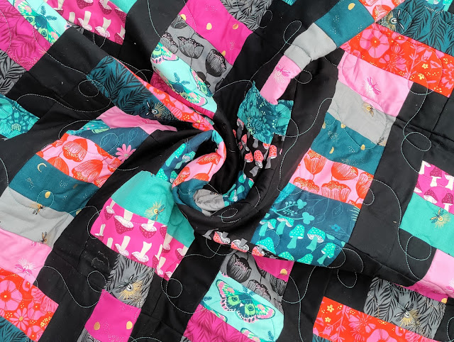 The Firefly collection sewn into a lap quilt using the Slice jelly roll pattern from Fat Quarter Shop