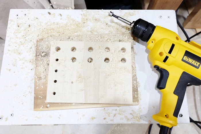 drilling holes in scrap wood for holding hand tools