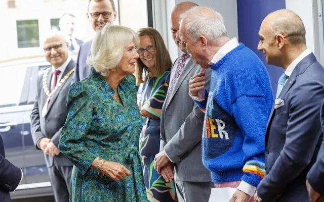 Queen Camilla wore a peacock-patterned dress by Liberty of London. Poetry Together was launched by Gyles Brandreth