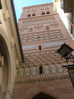 The tower of El Salvador features multiple levels of white and green ceramic tiles.