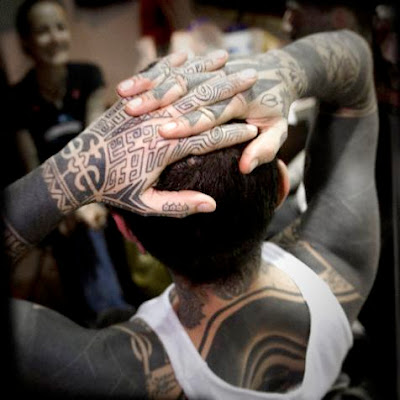 Maori black body tattoo on a white boy's body.