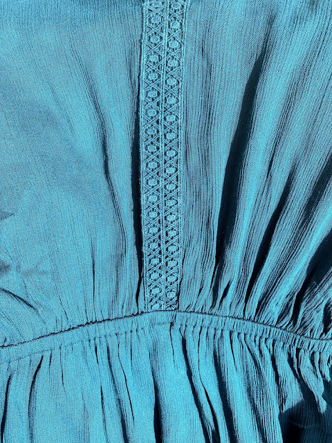 close up of elasticated waist and trim one teal maxi dress from Fashion World