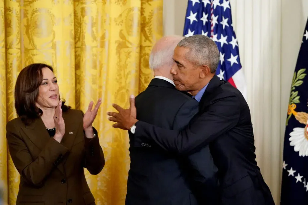 Vice President Kamala Harris (L) applauds as President Joe Biden and former President Barack Obama embrace prior to delivering remarks on the Affordable Care Act and Medicaid in the East Room of the White House in Washington, DC, on April 5, 2022.