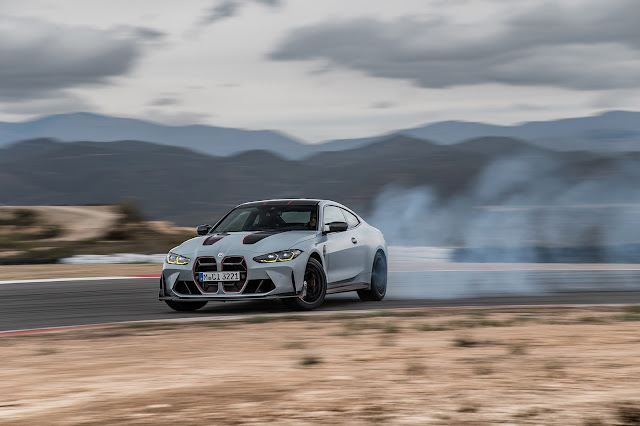 2023 BMW M4 CSL - front and left side view while drifting on the left hand race track turn.