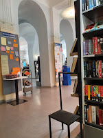 Open space with books filled shelves and colorful notice boards in public library