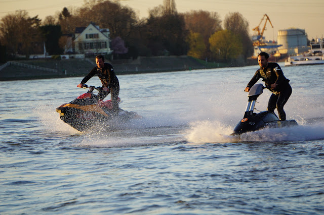 zwei_Jetskifahrer_auf_dem_Fluß_mit_Rheinhafen_im_Hintergrund