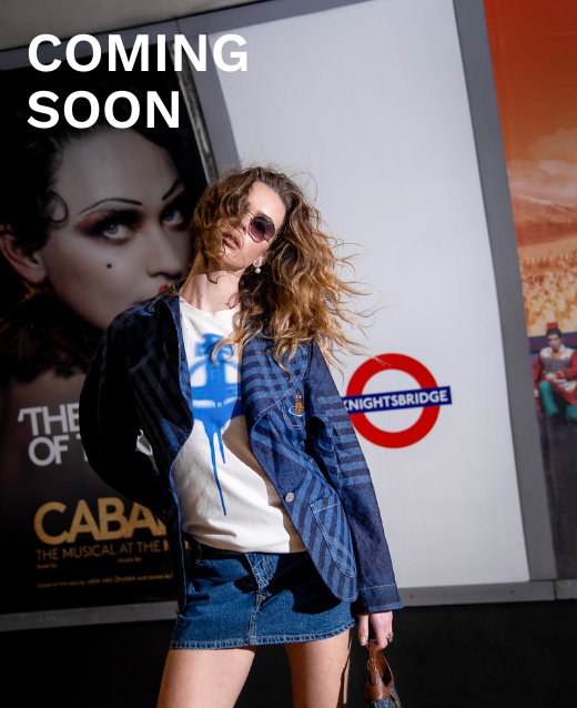 Female model stood in Knightsbridge tube station dressed in a preloved designer outfit. Clothing consists of: Vivienne Westwood Graphic T-Shirt, Vivienne Westwood Micro Denim Skirt and Vivienne Westwood Denim Jacket.