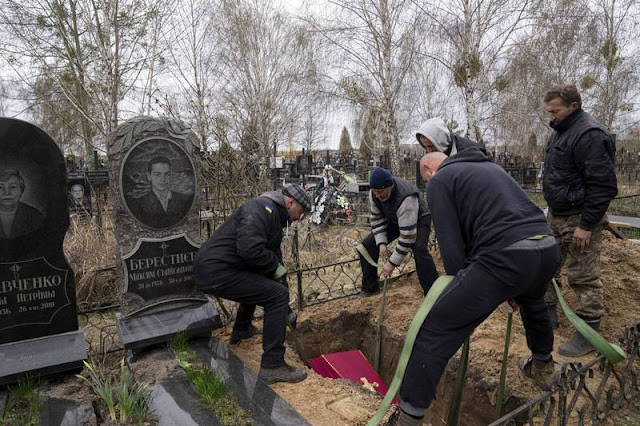 Minchenko (left) assisted in the burial of the dead. (Reuters)