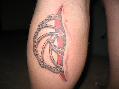 Metallic Ninja Star tattoo - left arm --A disc brake rotor that has been 