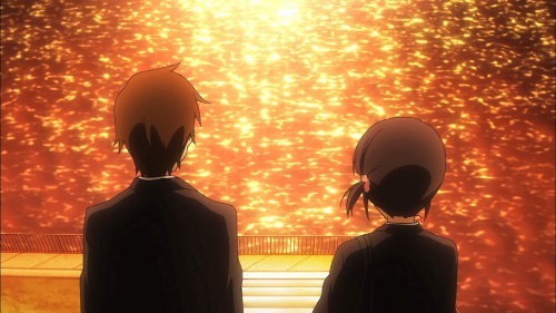 The backs of Taichi and Iori as they sit before a city river in the golden afternoon light