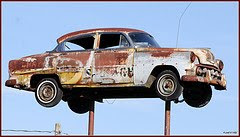 old rusted car on pole