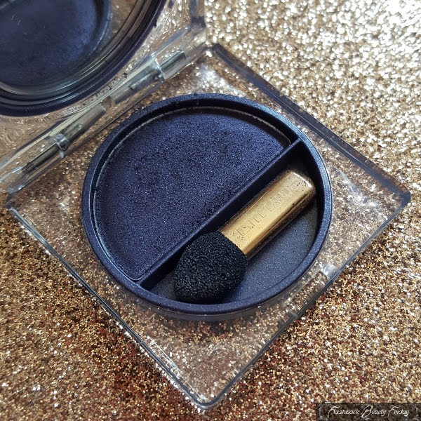 close up of transparent eyeshadow compact with midnight blue powder eyeshadow and small sponge applicator brush