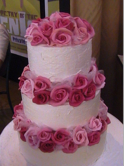 Three tier white wedding cake with roses