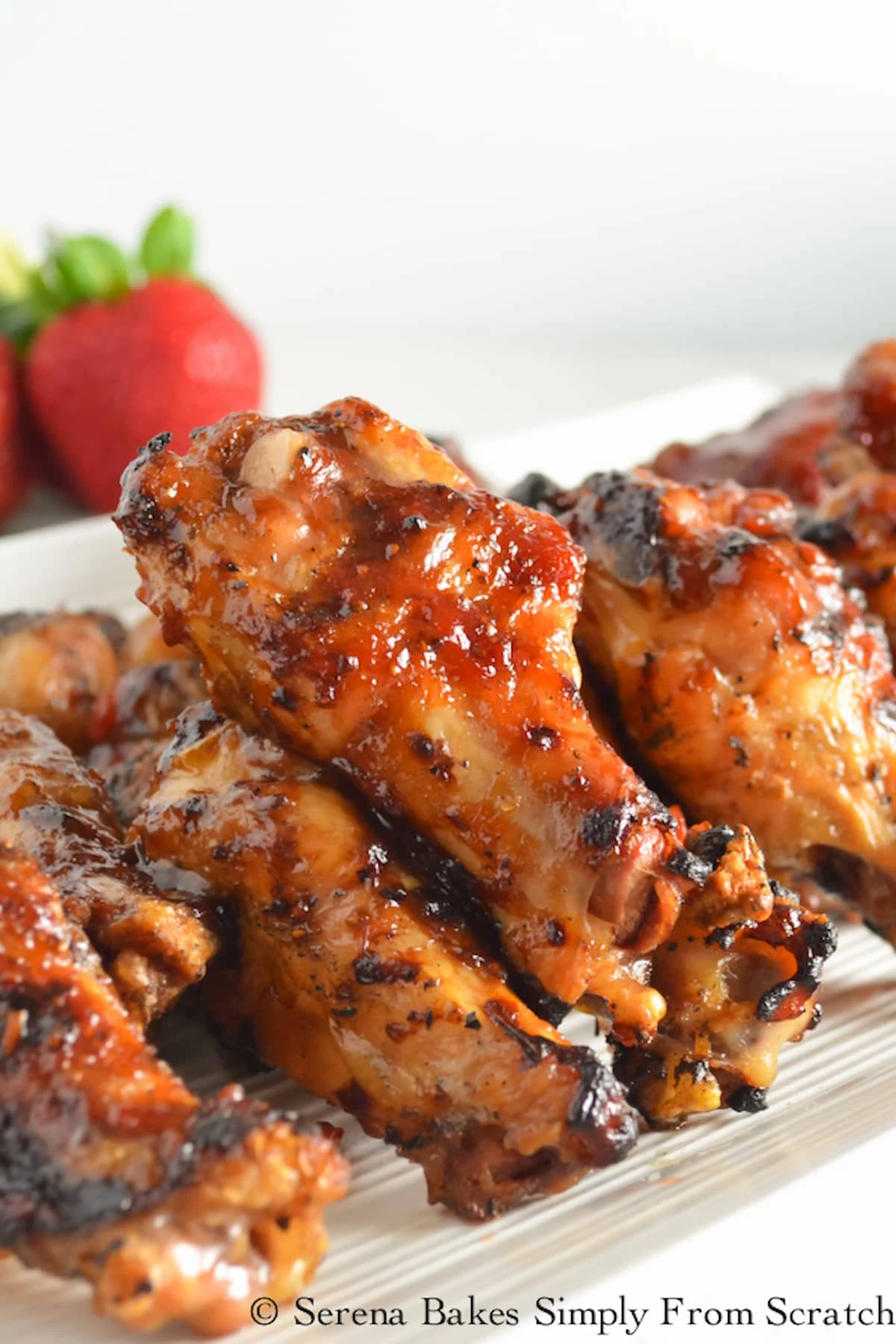 Strawberry Chipotle Hot Wings piled high on a white tray.