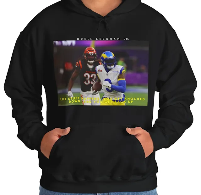 A Hoodie With NFL Player Odell Beckham Jr Running Holding the Duke & Quote Life Stuff Happens You Get Knocked Down, and You Get Back Up